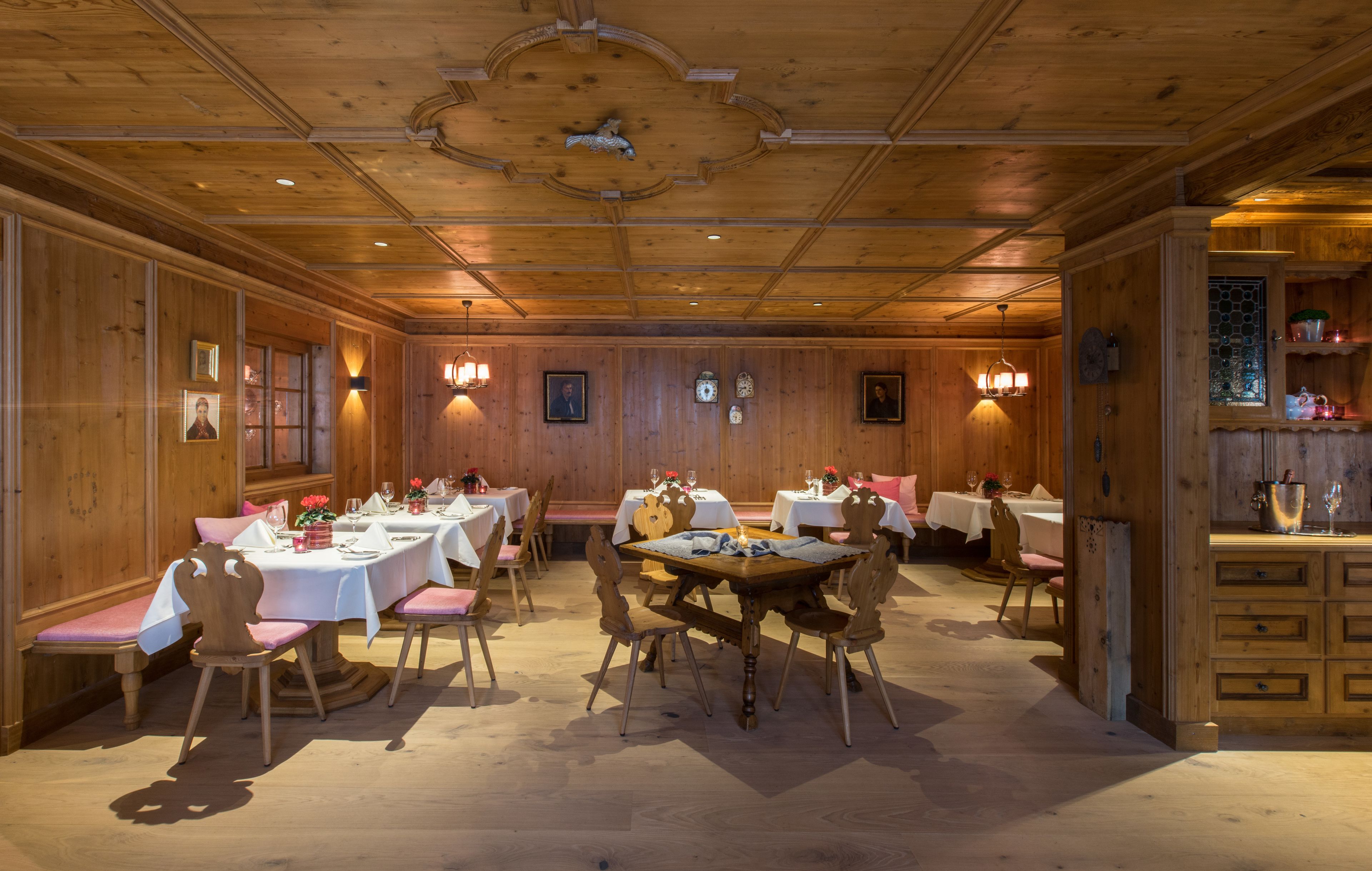 A dining area with wooden walls, multiple tables, and chairs.