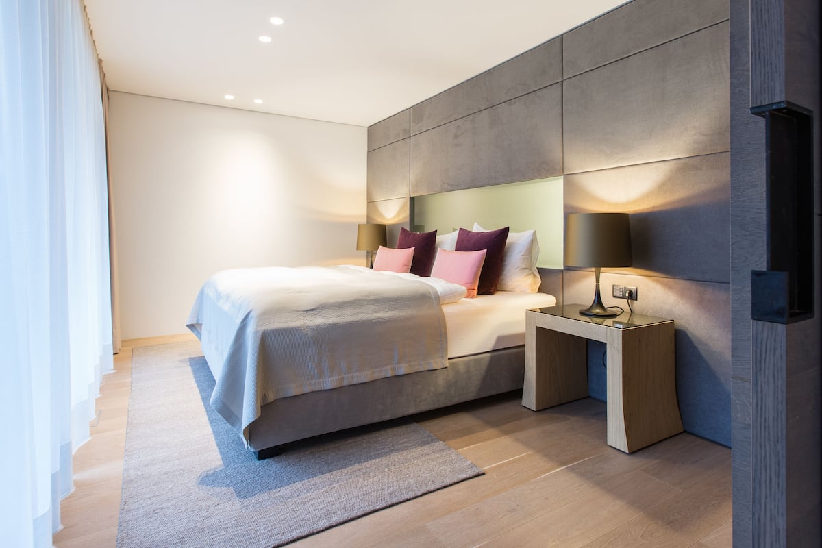 Une chambre à coucher moderne avec un lit, des tables de chevet et une commode.