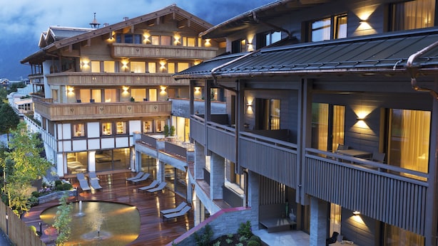 Een meerlaags hotel met terras en zwembad.