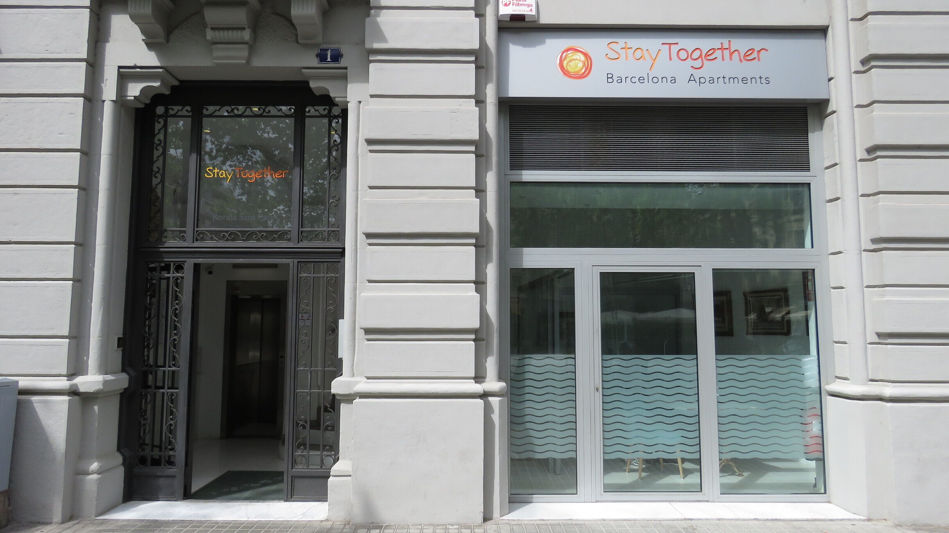 Een gevel met een bord waarop staat: Stay Together Barcelona Apartments.