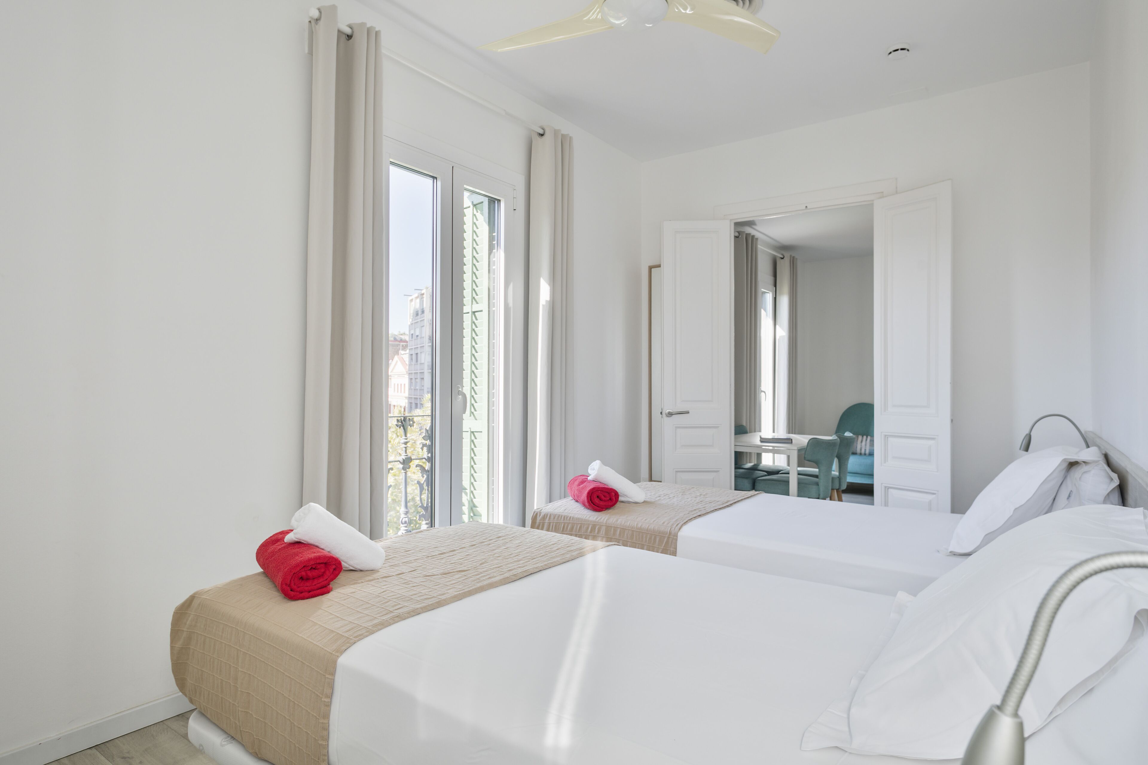 Een hotelkamer met twee bedden, een badkamer en uitzicht op de stad.