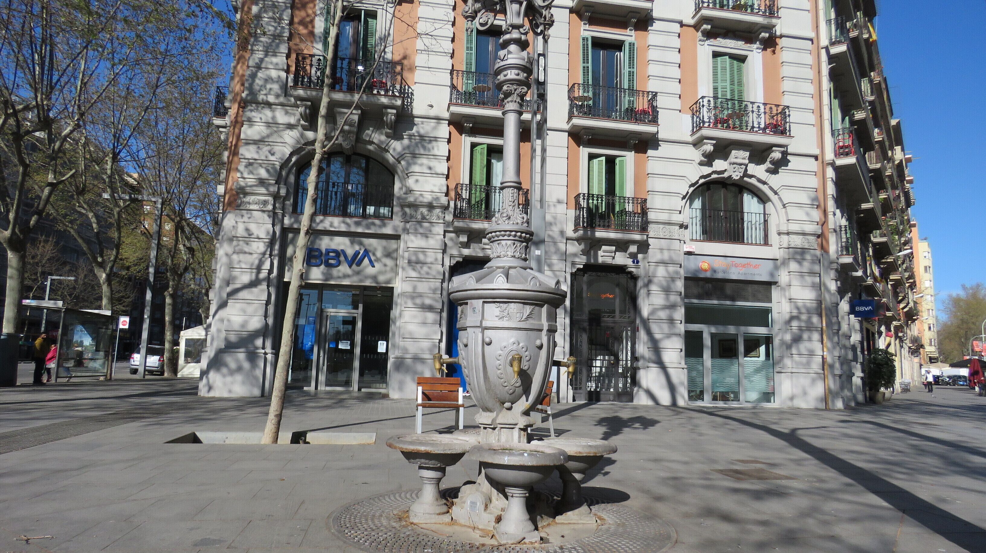 Een gebouw met een 'BBVA' bord, een fontein en een 'CityTogether' bord.