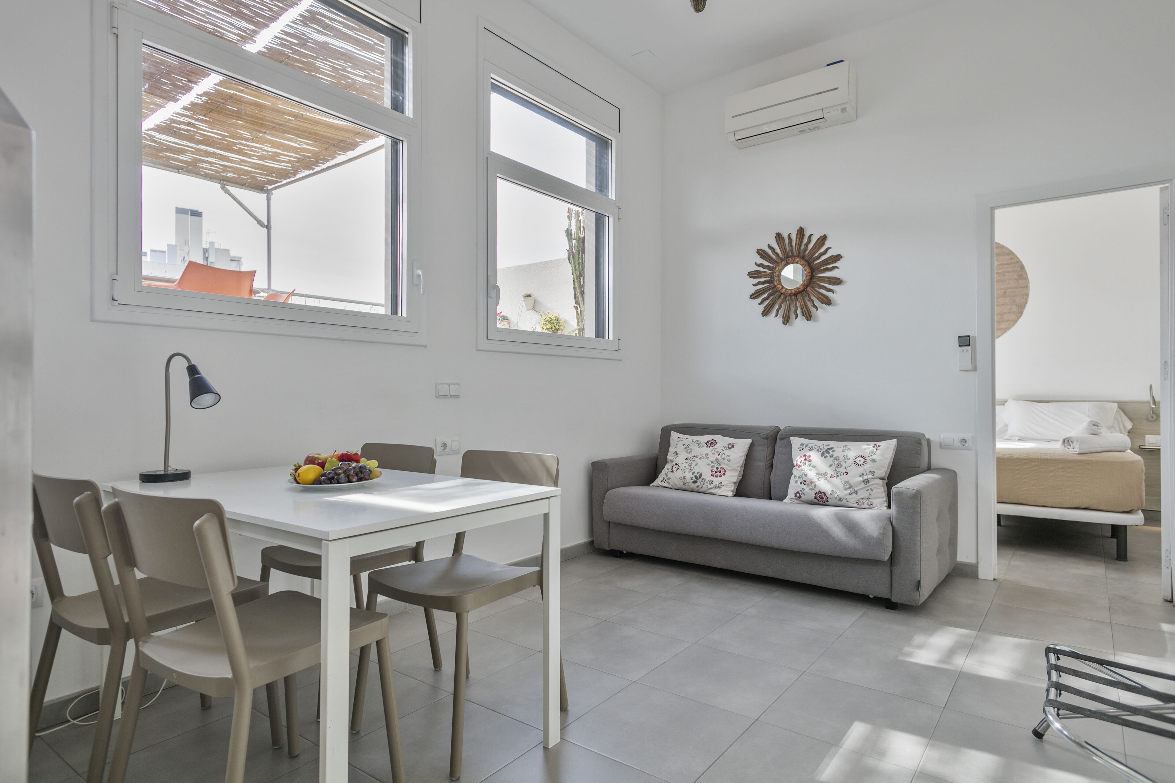 Un espace de vie moderne comprenant un coin repas, un canapé et un lit.