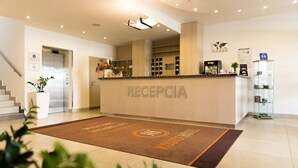 A hotel reception area with a reception desk, a staircase, and a reception desk sign. - Košice Hotel (Kosice)