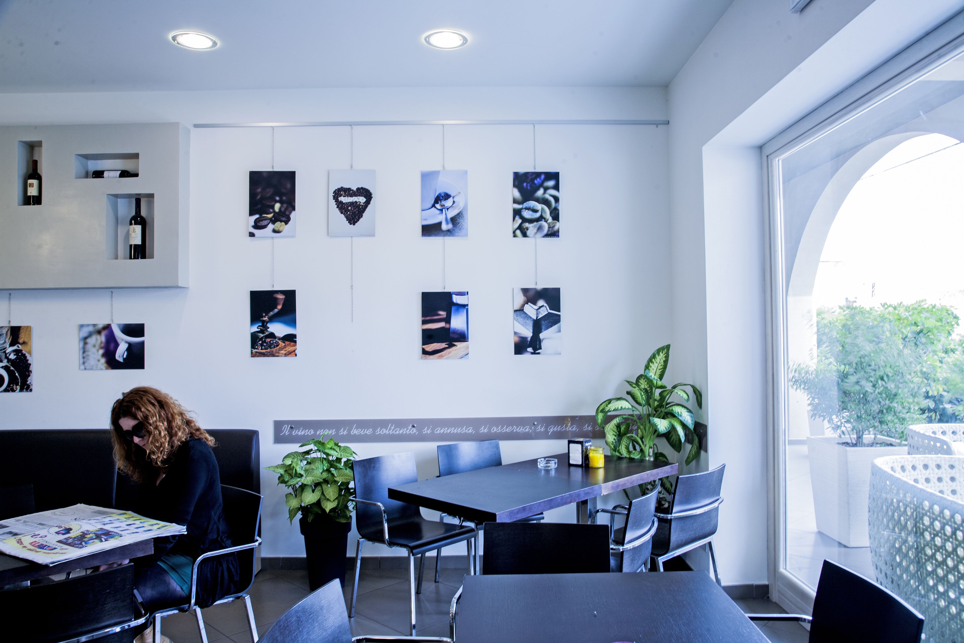 A modern interior with a dining area, seating, and a wall with various framed pictures.