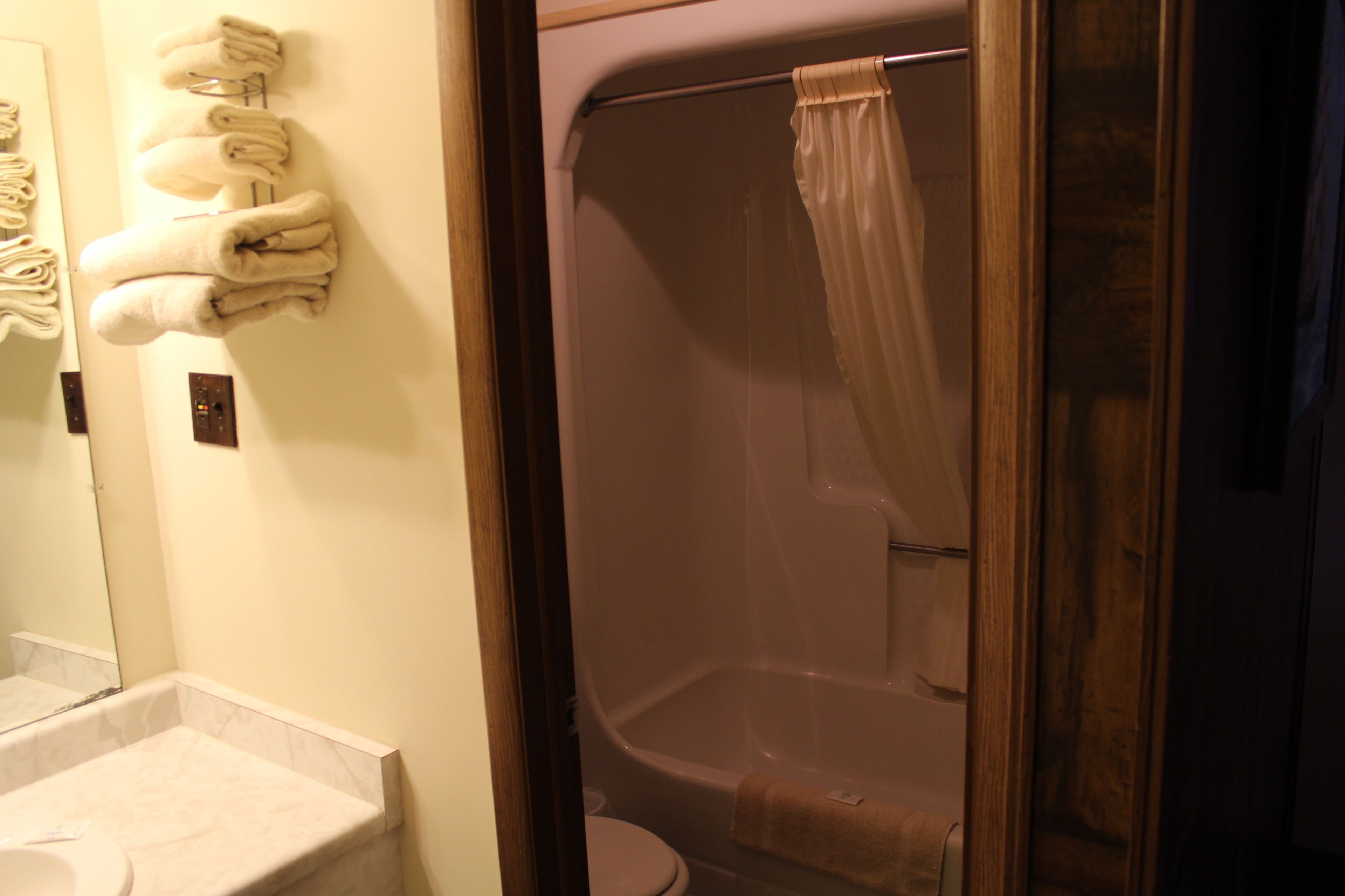 Une salle de bain équipée de toilettes, d’un lavabo et d’une douche avec un rideau.