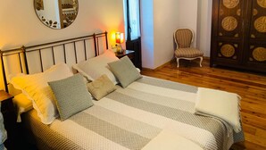 A bedroom with a bed, a chair, a wardrobe, and a mirror. - Casa Rural Argonz Etxea (Urzainqui)