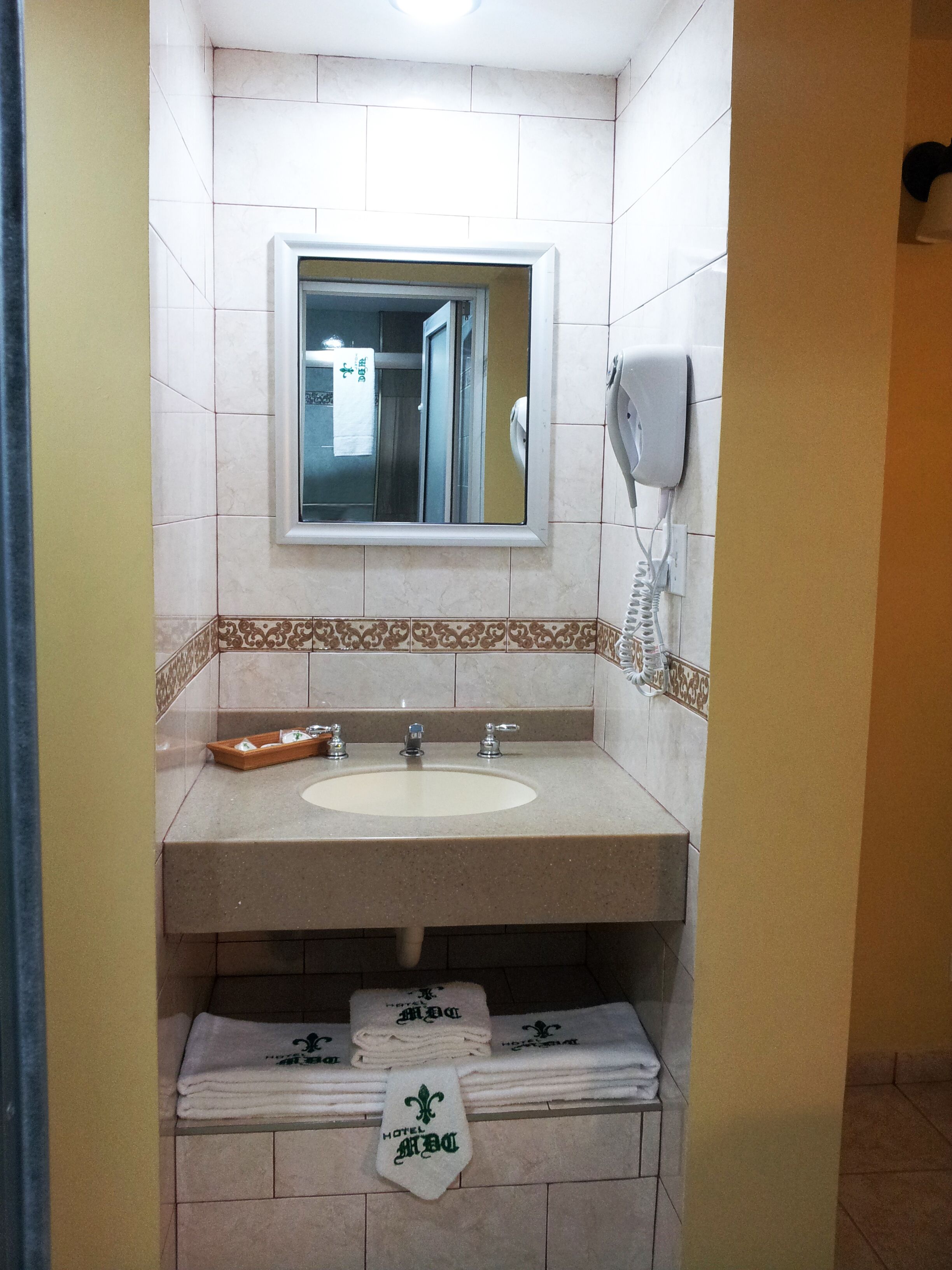 A bathroom with a sink, mirror, and towel rack.