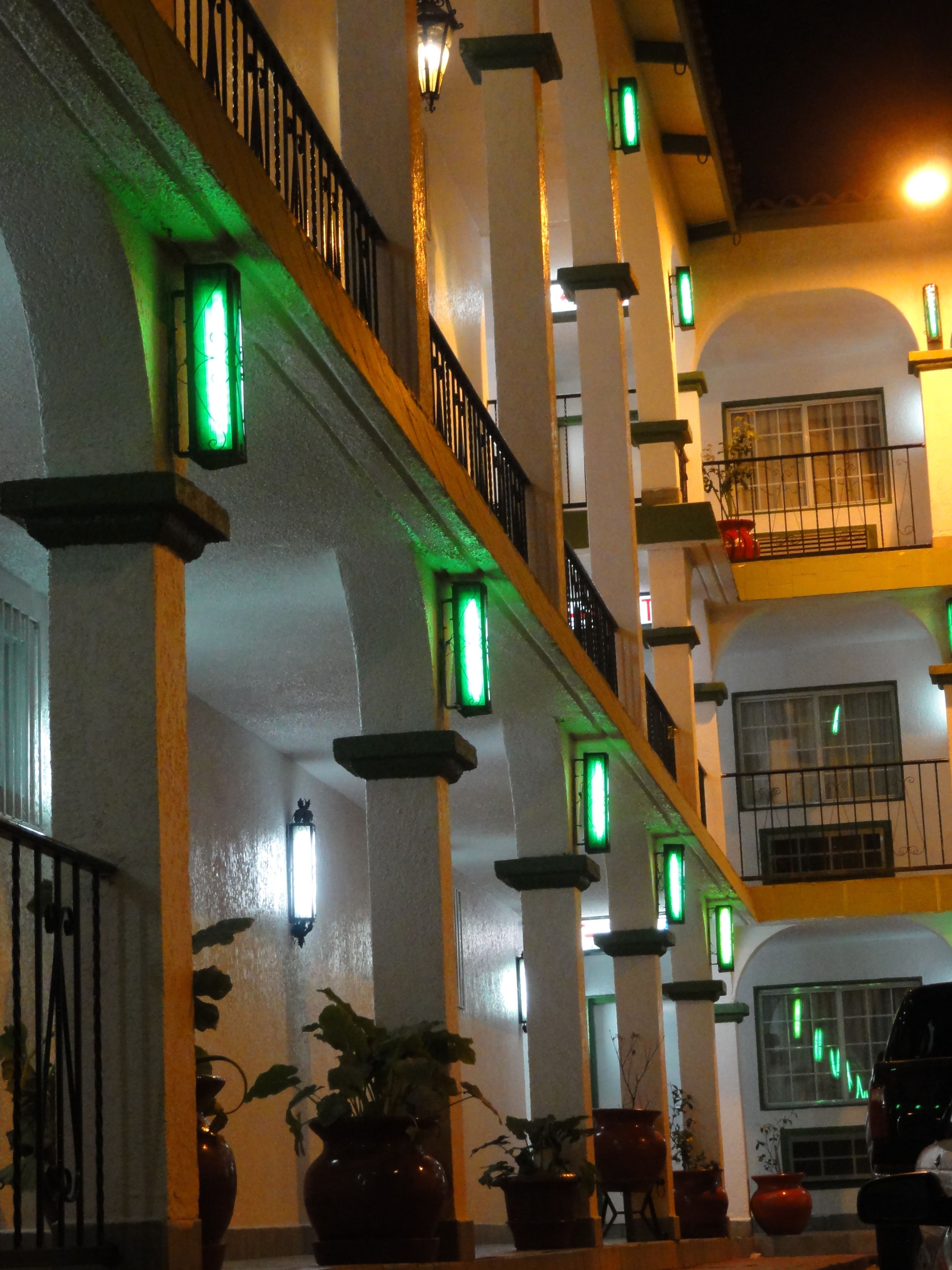 Un edificio con varios balcones, cada uno con barandilla y macetas.