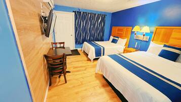 A hotel room with two beds, a dining table, and a small seating area.