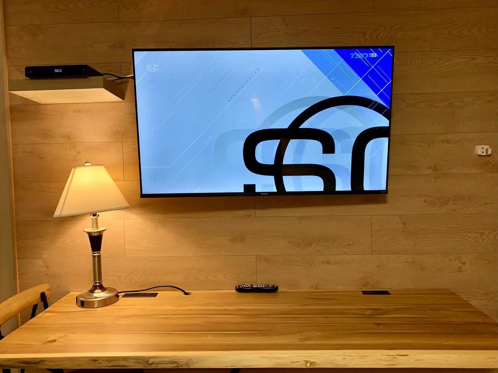 A television mounted on a wooden wall displaying a sports channel logo.