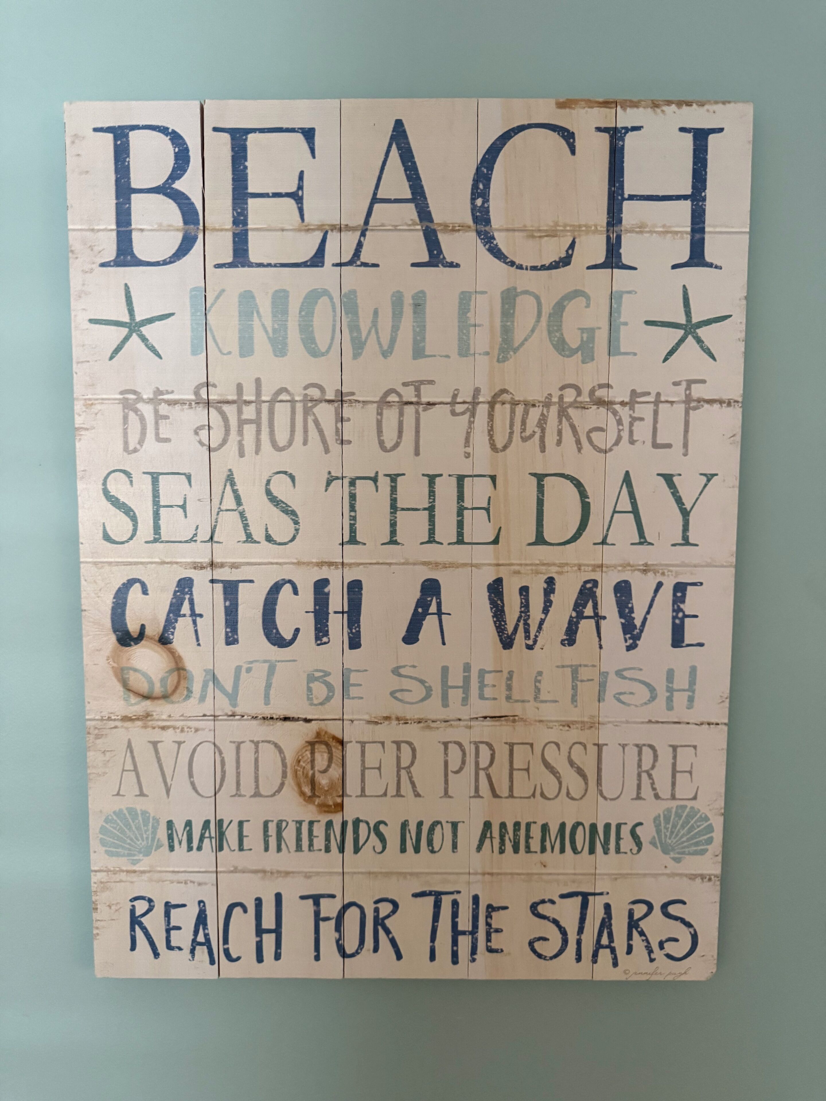 Un letrero de madera con frases motivacionales.