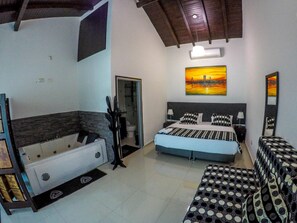 A bedroom with a bed, a large window, a bathroom, and a ceiling fan. - La Cabrera Hotel Boutique (Neiva)