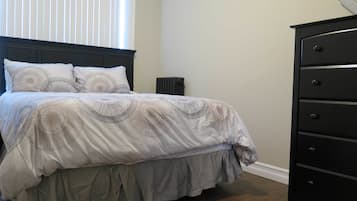 Un dormitorio con cama, cómoda y radiador.