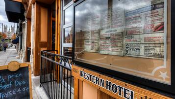 A menu board outside a Western Hotel with a sign indicating it opened in 1881.