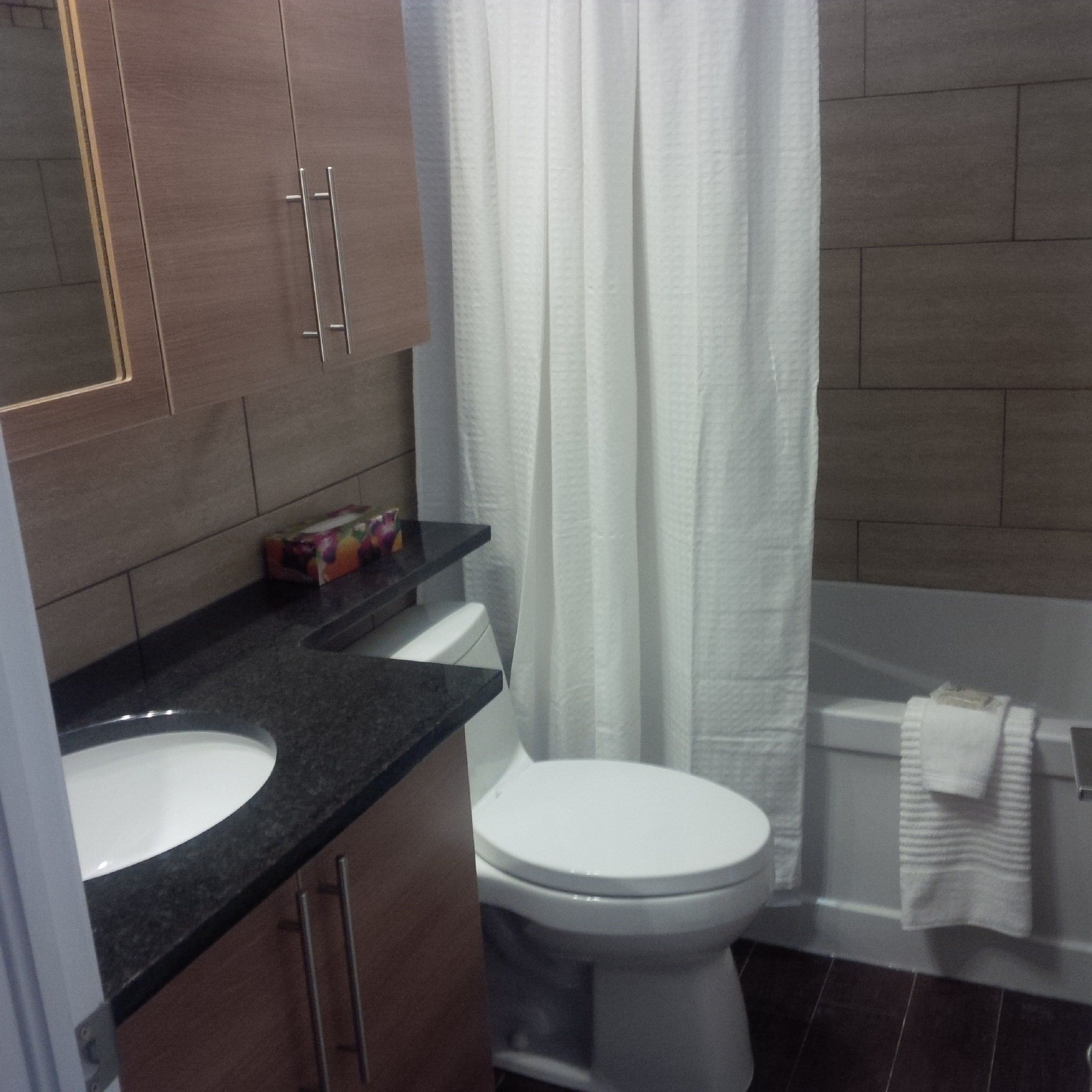 Un baño con inodoro, lavamanos y cabina de ducha.