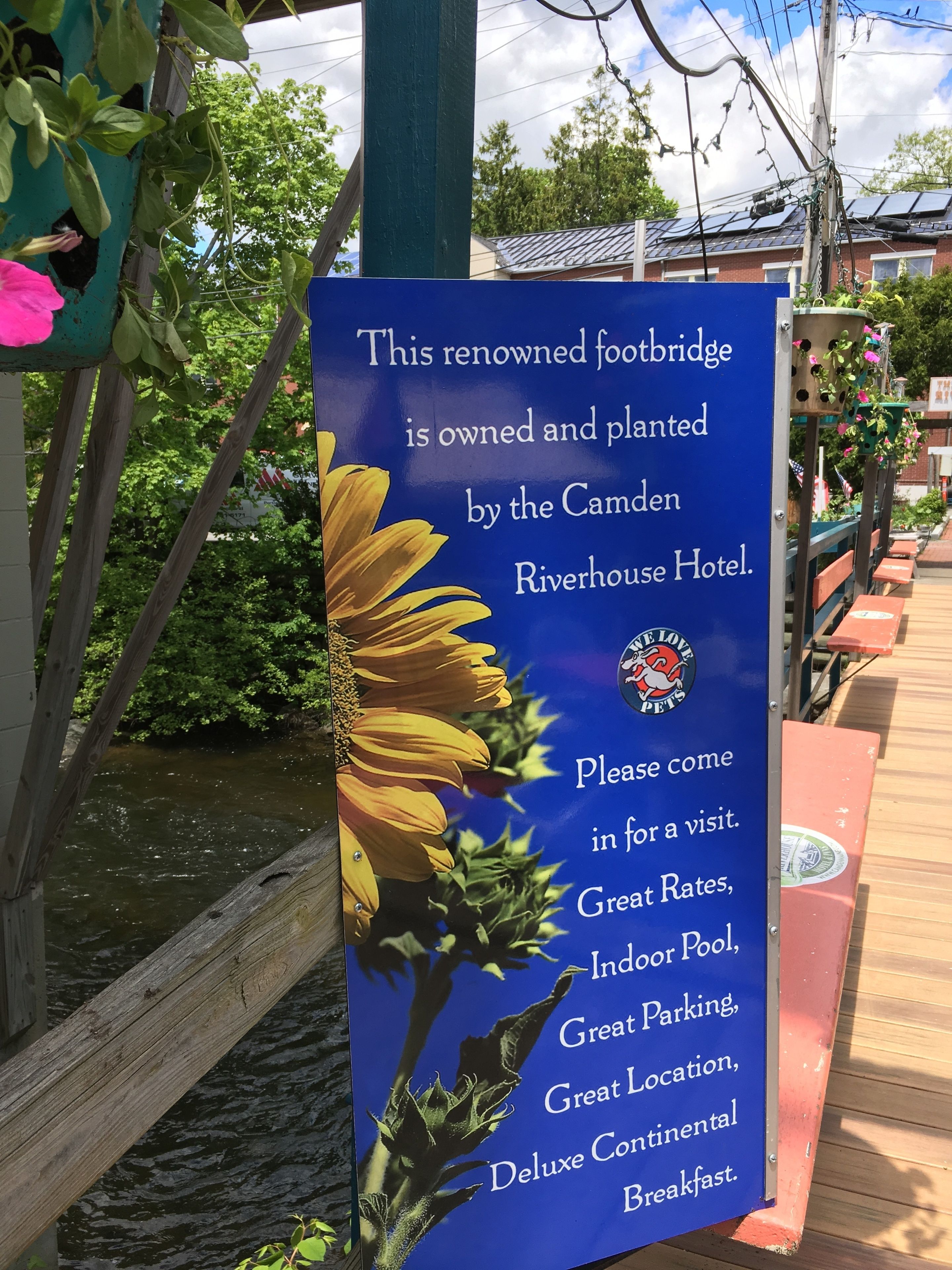 Letrero publicitario del puente peatonal del Hotel Camden Riverhouse, destacando servicios como tarifas especiales, piscina cubierta y desayuno continental.