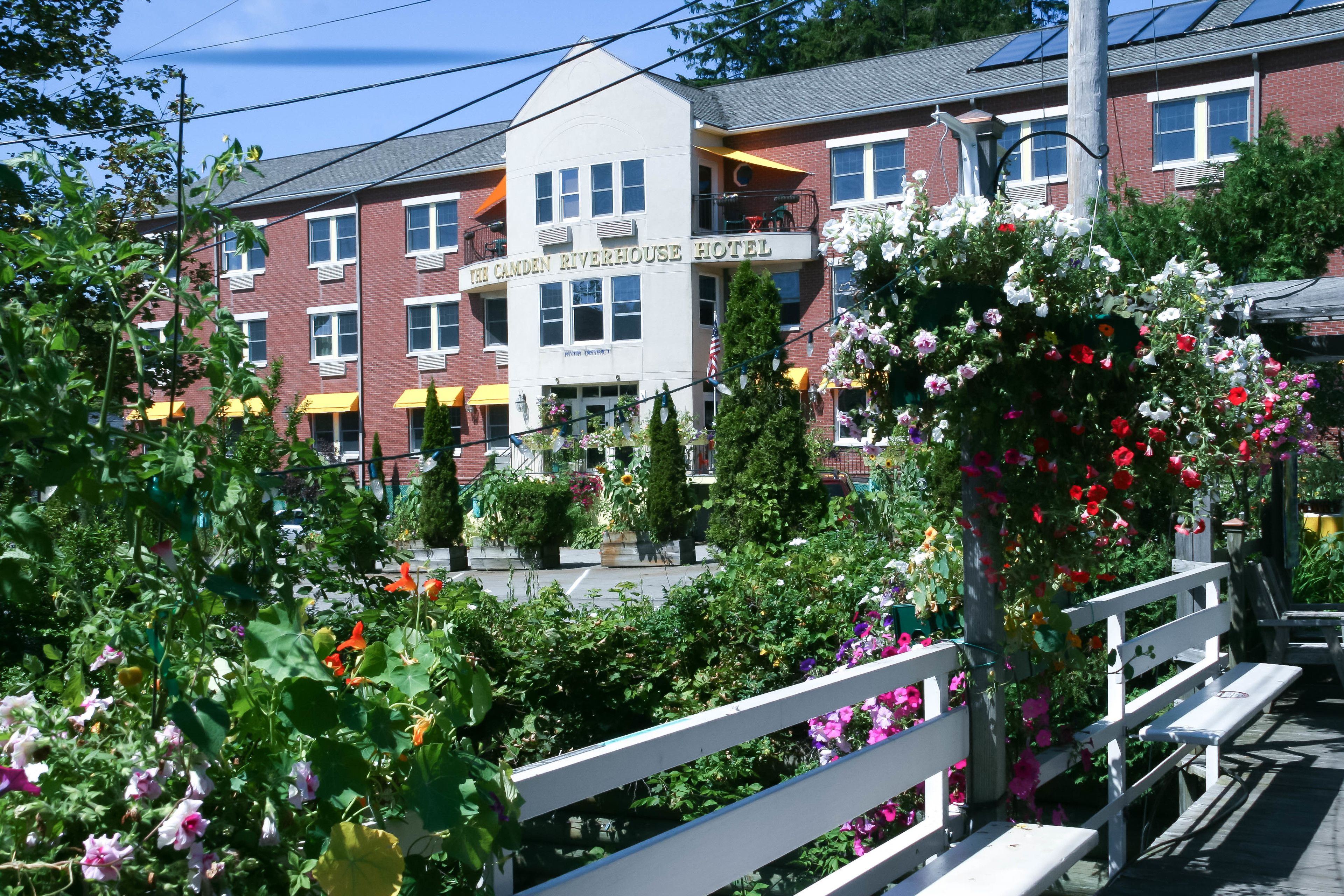 Hotel Camden Riverhouse, con vistas a un jardín, una cerca blanca y una banca.
