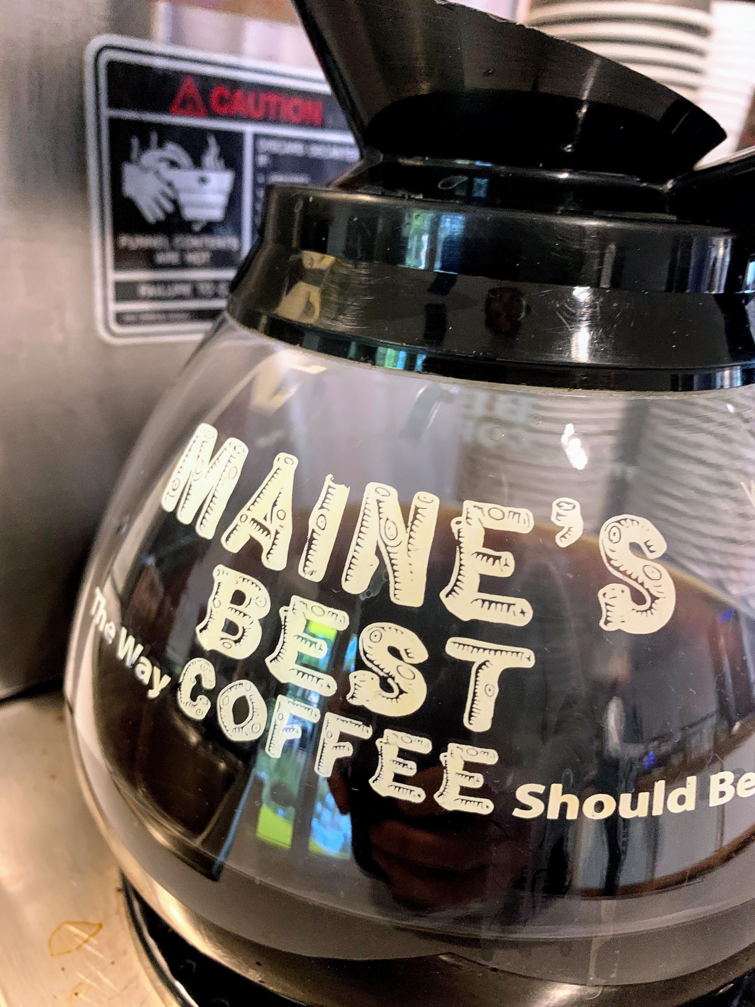 Een koffiezetapparaat met de tekst 'MAINE'S BEST COFFEE Should Be'.