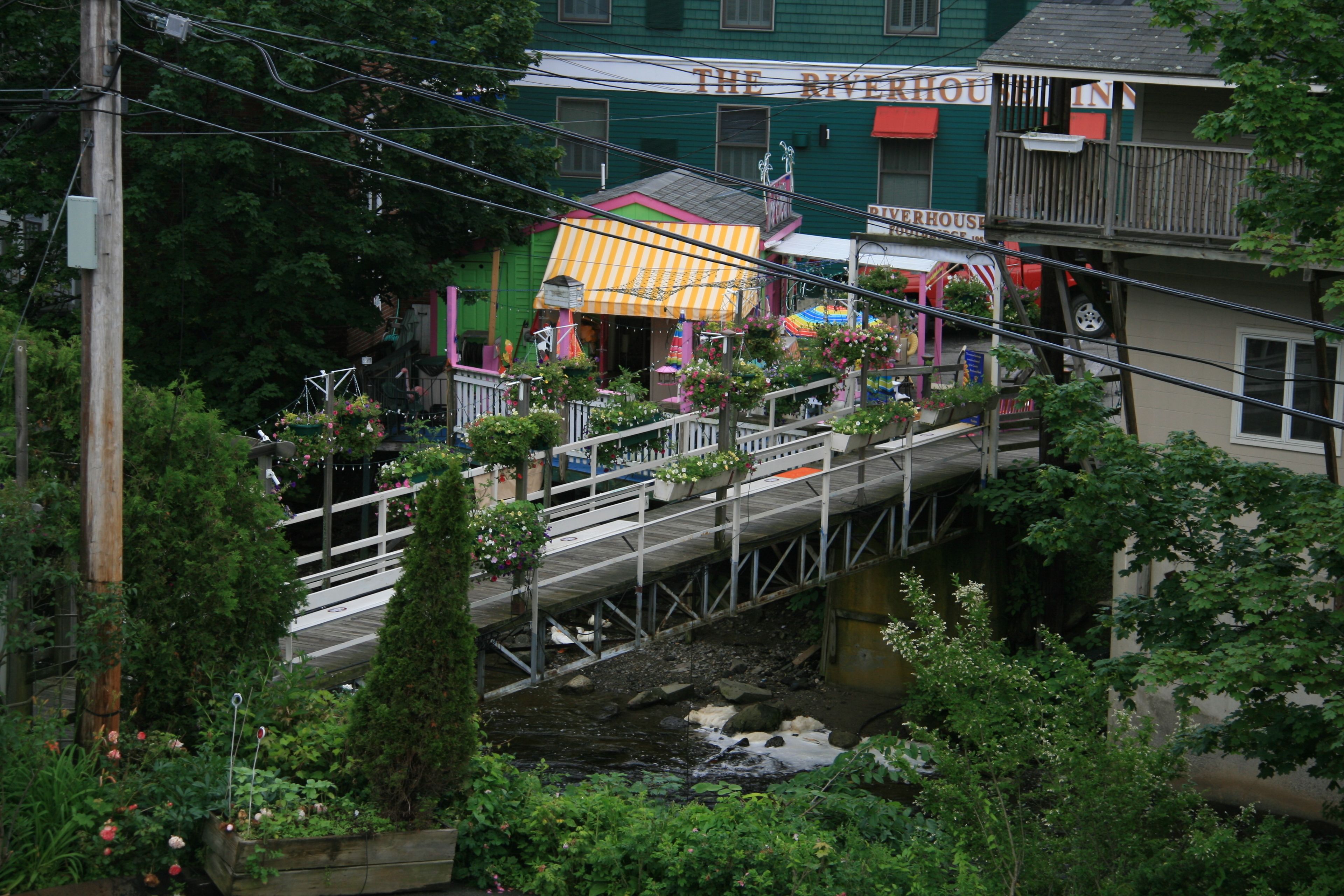 Un hôtel situé au bord de la rivière, relié au bâtiment principal par un pont.