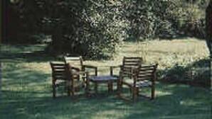 A table and four chairs in a grassy outdoor area. - Chesapeake Inn of Lenox (Lenox)