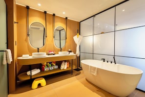 Une salle de bain moderne avec une baignoire sur pieds, deux vasques et un grand miroir.