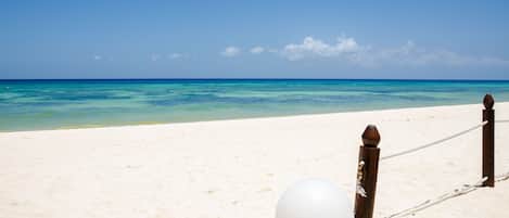 På stranden, vit sandstrand, solstolar och parasoller