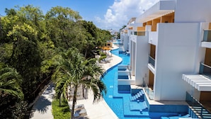 Un complejo turístico con piscina, palmeras y arquitectura moderna.