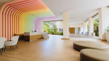 Een moderne receptie met een vloeiende wand, een receptiebalie, een zithoek en uitzicht op het omliggende landschap.