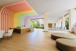 A modern reception area with a curved wall design, a reception desk, seating area, and a view of the outdoors.