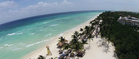 On the beach, white sand, sun-loungers, beach umbrellas
