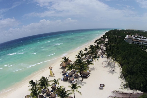 On the beach, white sand, sun loungers, beach umbrellas