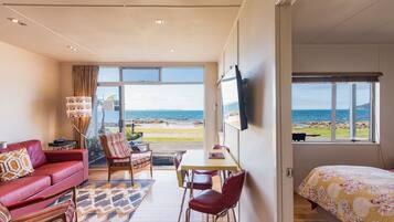 Apartamento Premium, 2 habitaciones, vistas a la playa | Zona de estar | Televisión de plasma de 42 cm con canales por satélite, una televisión
