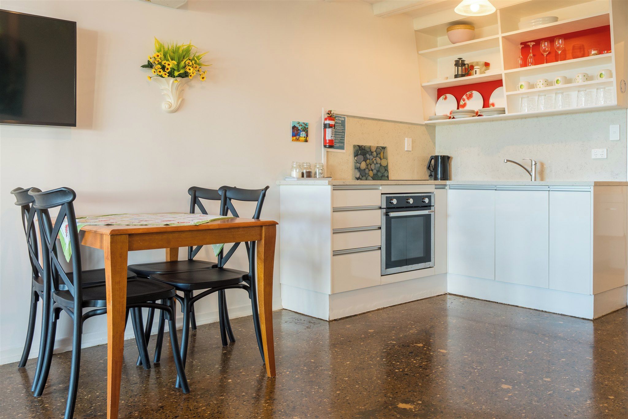 A kitchen with a dining table, chairs, a stove, and a sink.
