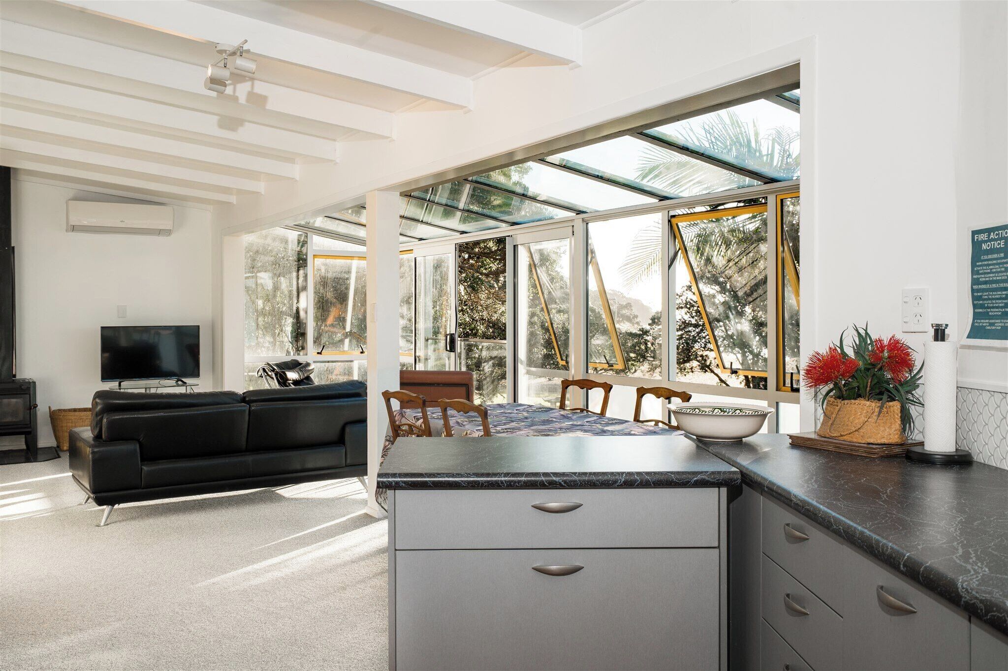 A modern living space with a kitchen area, a dining table, and a sofa.