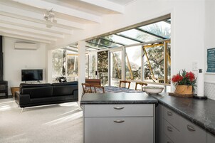 A modern living space with a kitchen area, a dining table, and a sofa.