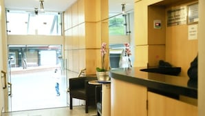 Un espace d’accueil avec un comptoir, des chaises et une plante.