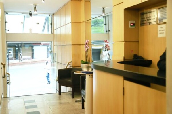 A reception area with a counter, chairs, and a plant.