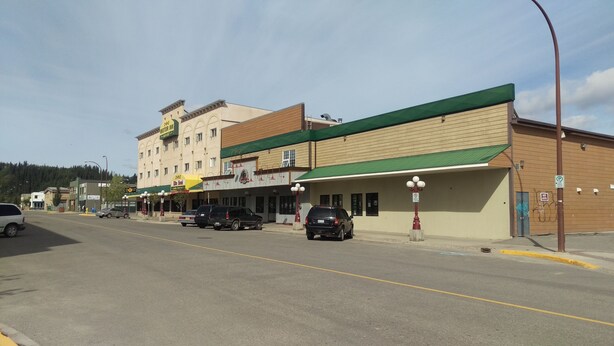 A building with a green awning and a sign for a hotel.