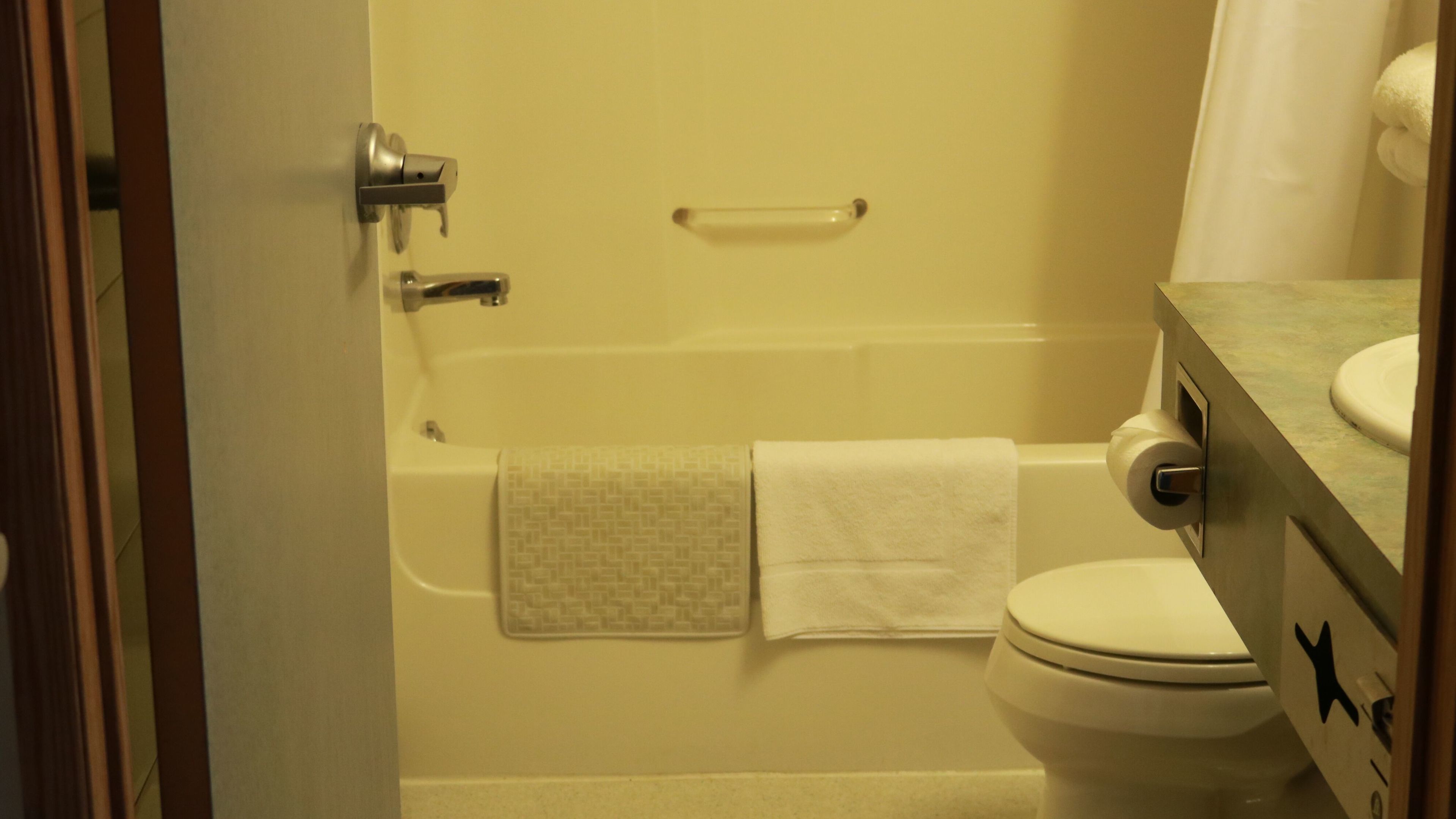 A bathroom with a bathtub, toilet, and a sink.
