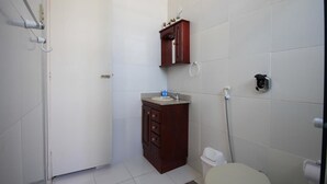 Een kleine badkamer met toilet, wastafel en douche.