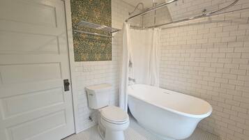 Un baño con inodoro, bañera y ducha.