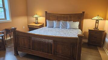 A wooden bed with a headboard, two bedside tables with lamps, and a nightstand.