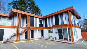 A modern building with a two-story structure, a staircase, and a small porch area. - The Spot (Nanaimo)