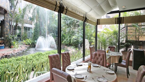 Un restaurant amb vistes a una zona aquàtica i vegetació exuberanta.