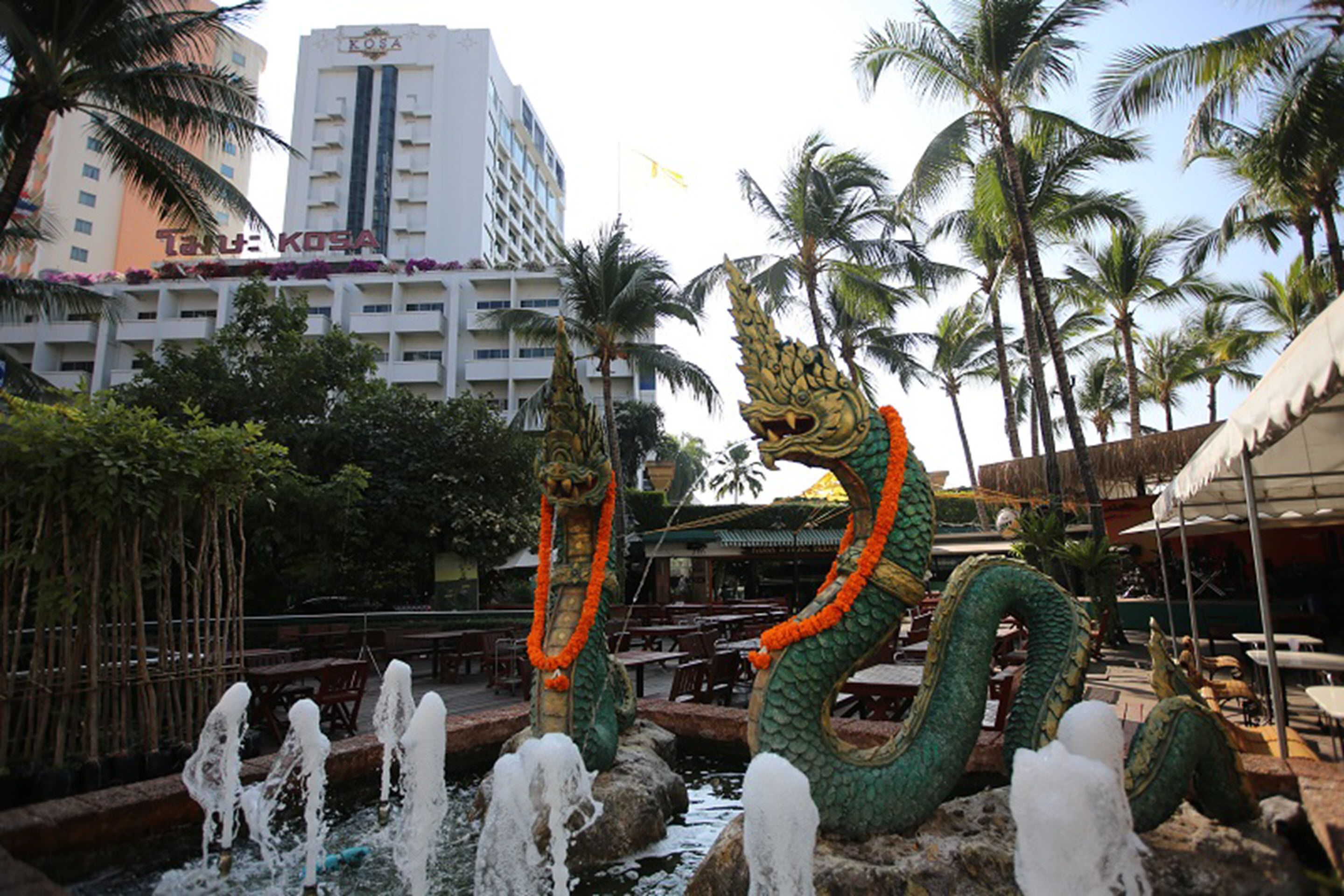 A hotel with a water feature and dragon statues.