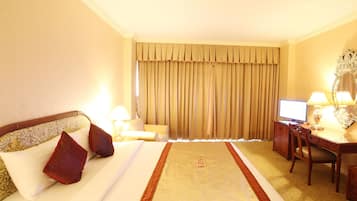 Une chambre d’hôtel équipée d’un lit, d’un bureau, d’une chaise, d’une télévision et d’une lampe.