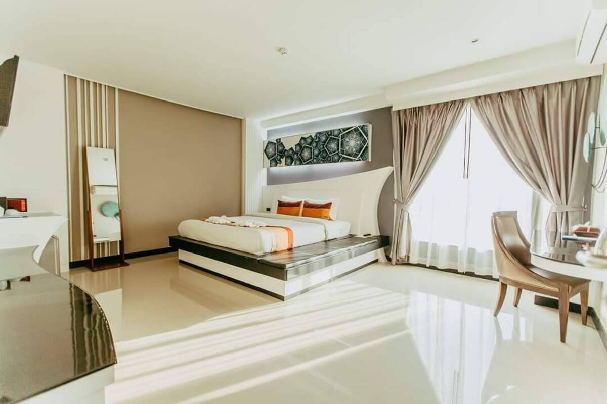 Habitació d'hotel moderna amb un llit, un escriptori i una cadira.