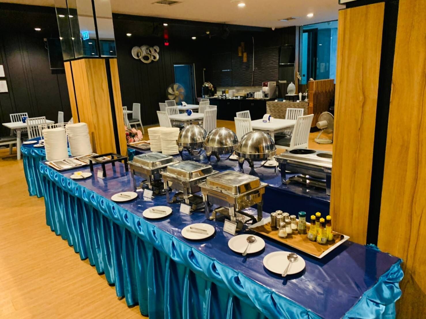 A buffet setup with multiple serving stations, white plates, and silver serving dishes.