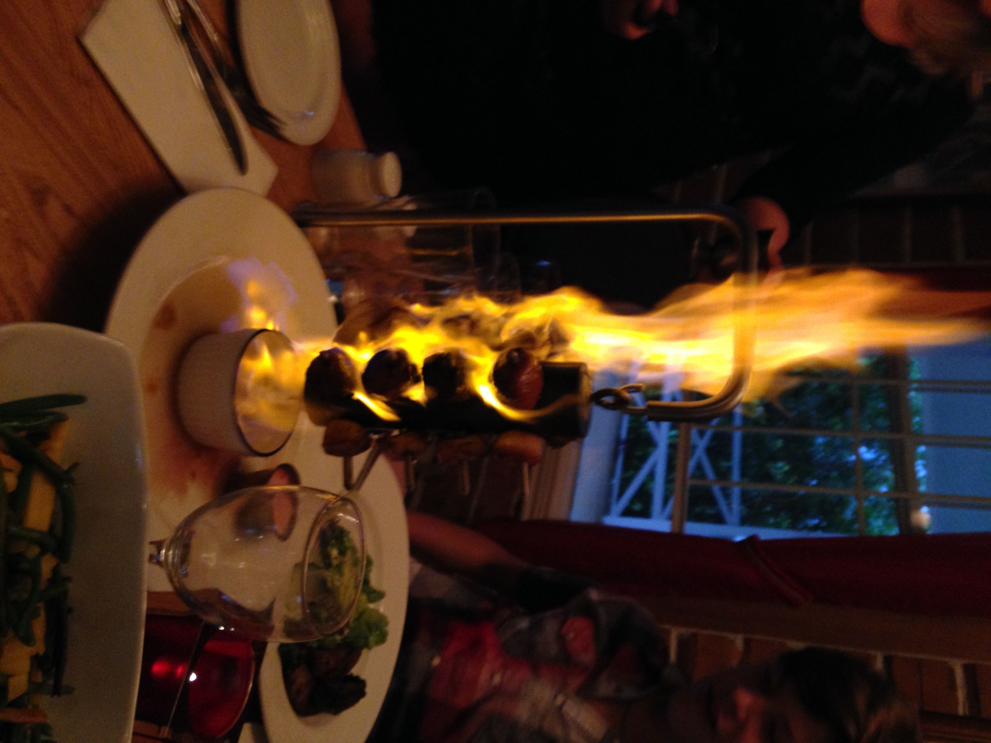 Een eettafel met kandelaar en een glas water.